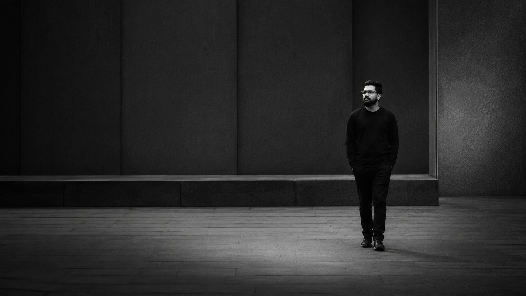 Ahammed Hasan small against a large dark architectural space