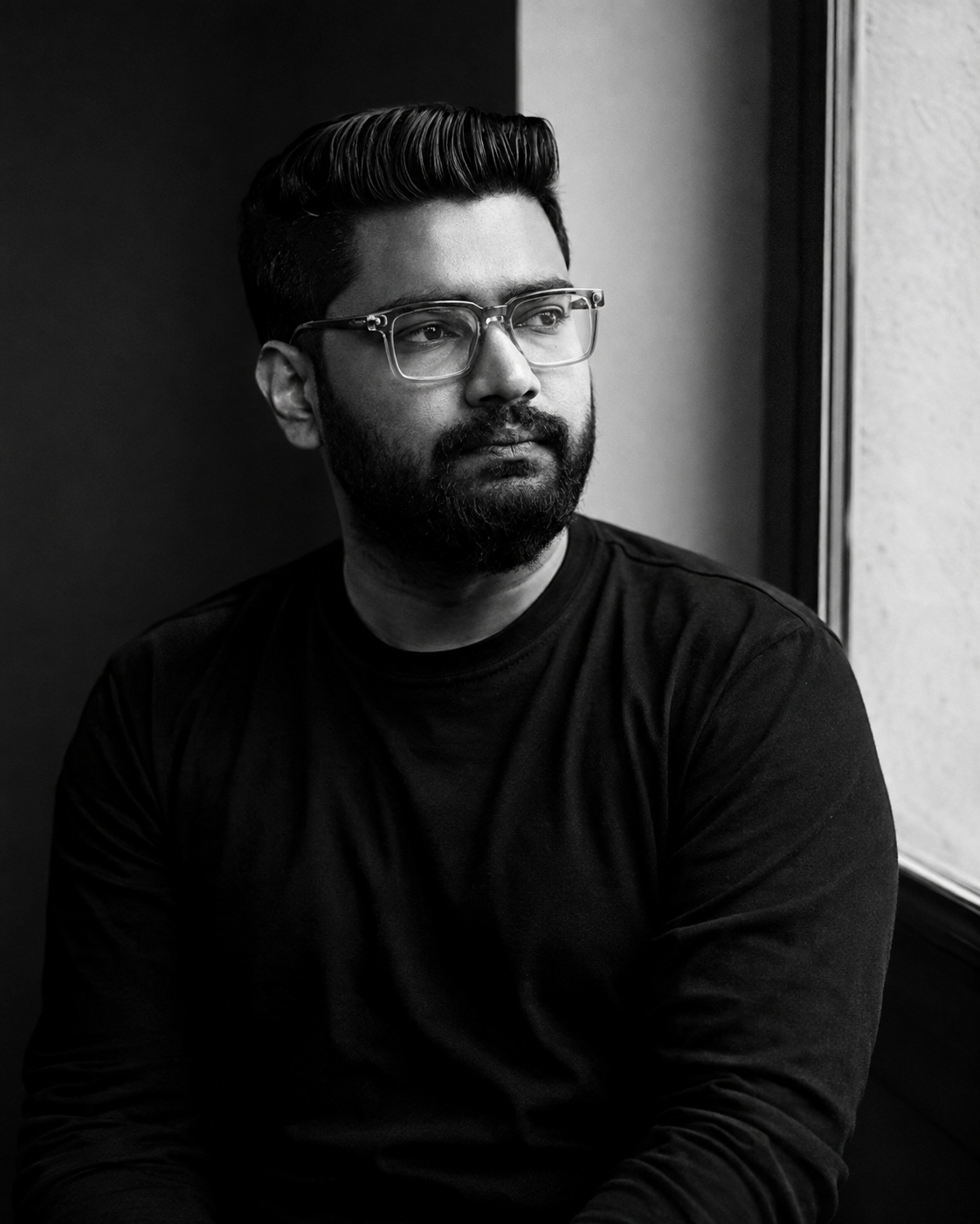 Ahammed Hasan sitting beside a window, looking away